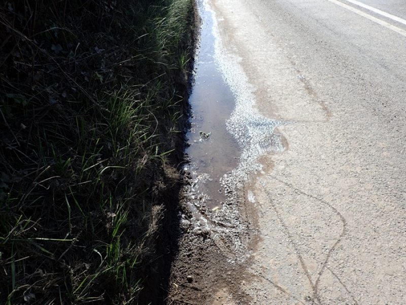 Water emerging from under road 
